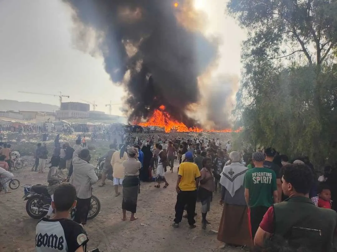 مواطنون وهم يشاهدون ألسنة اللهب والدخان وهو يتصاعد من مساكن المهمشين