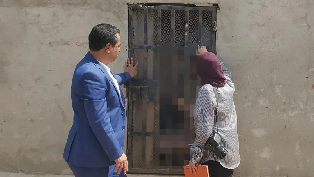 أعضاء اللجنة أمام باب أحد زنازين الاعتقال بسقطرى